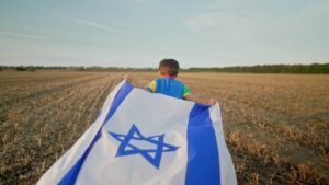 ילד רץ עם דגל המדינה בשדה פתוח